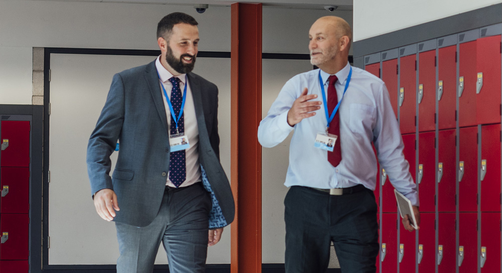 Two men walking in the hallway