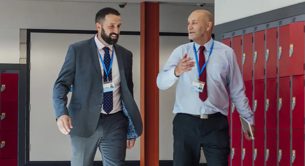 Two men walking in a hallway
